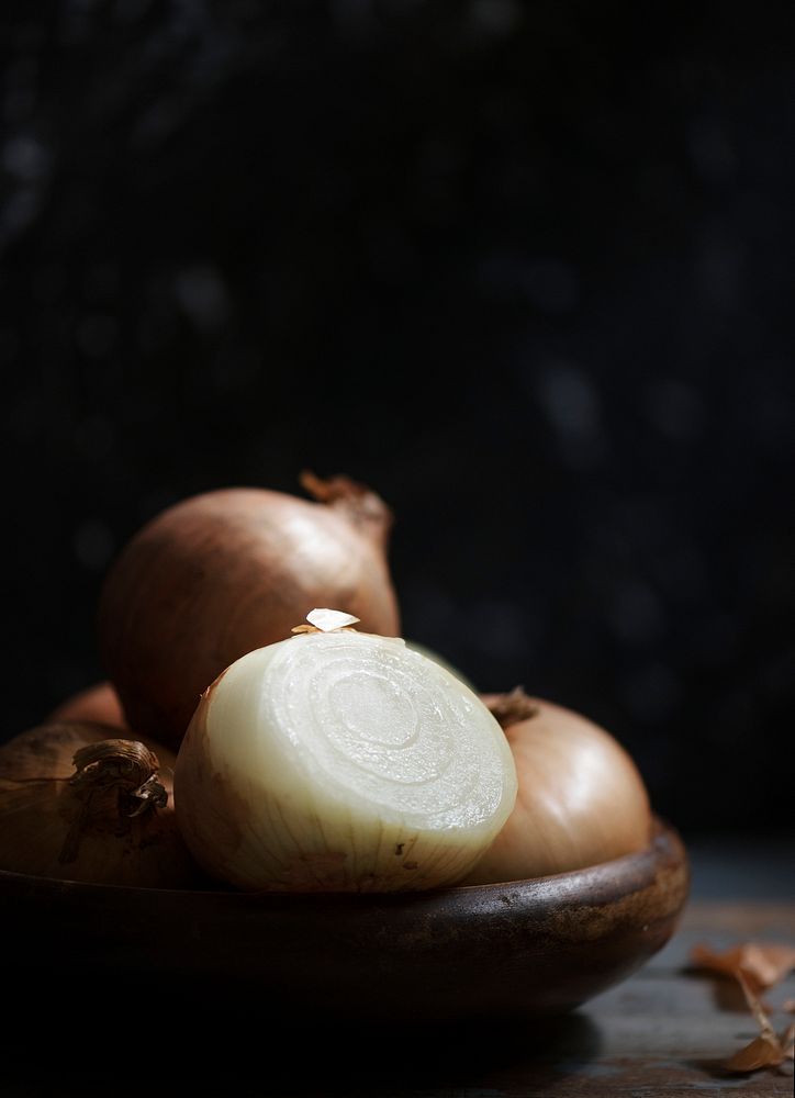 Closeup of fresh onions in wooden bowl