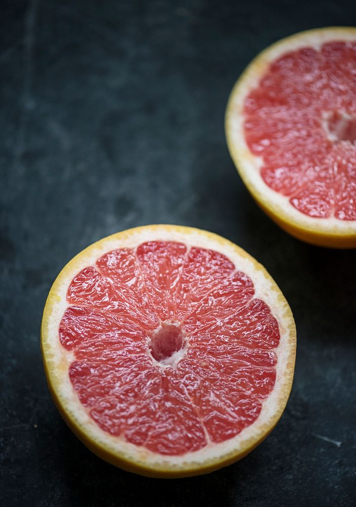 Closeup of grapefruit slices on black table