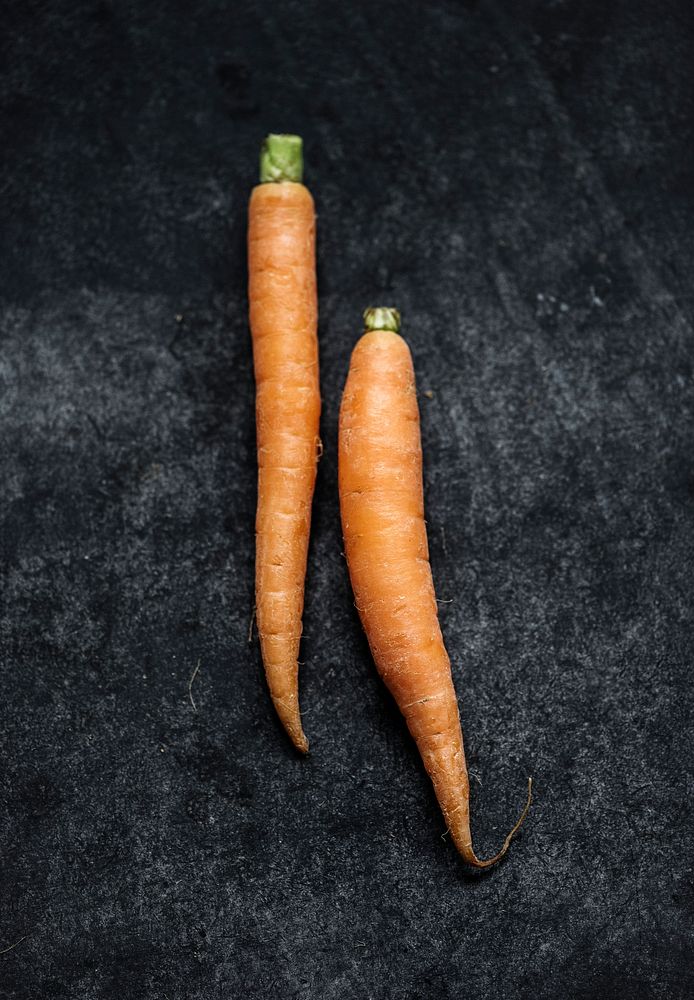 Closeup of yellow fresh organic carrots on black background