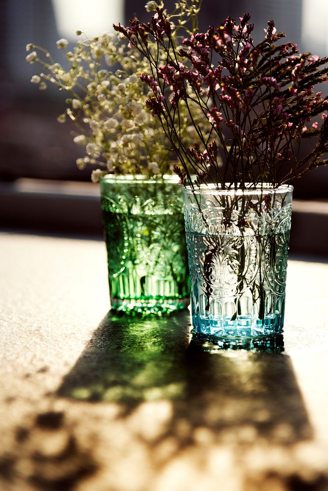 Closeup of flowers in glass vases on wooden table