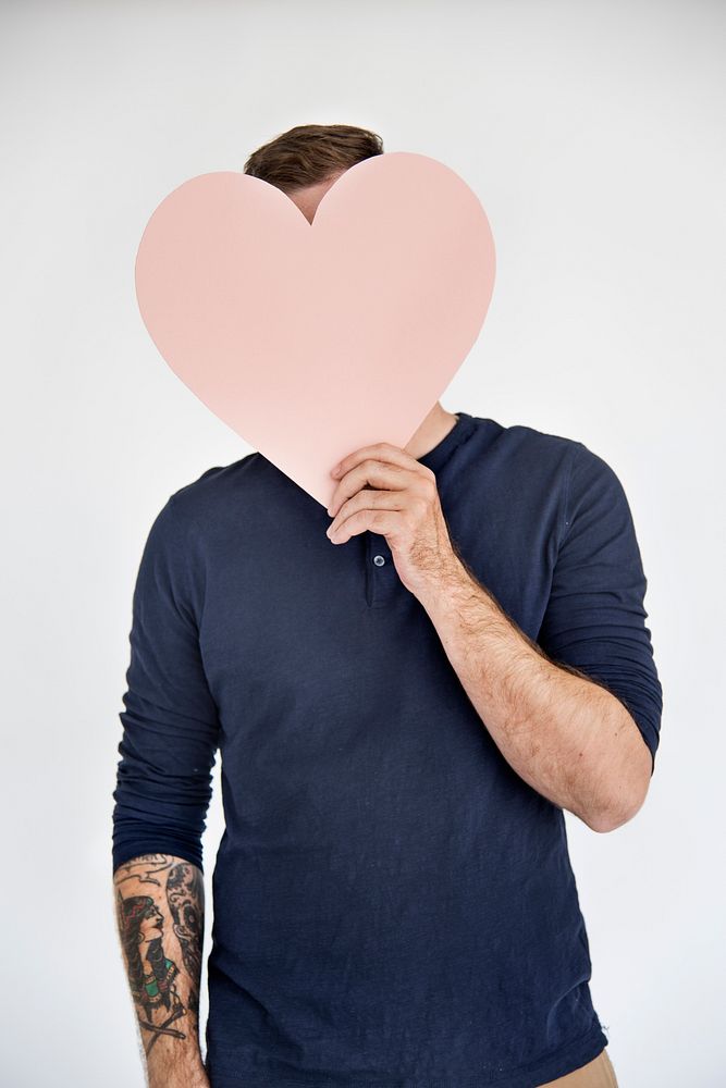 Man Holding Heart Sign Covering Face Concept