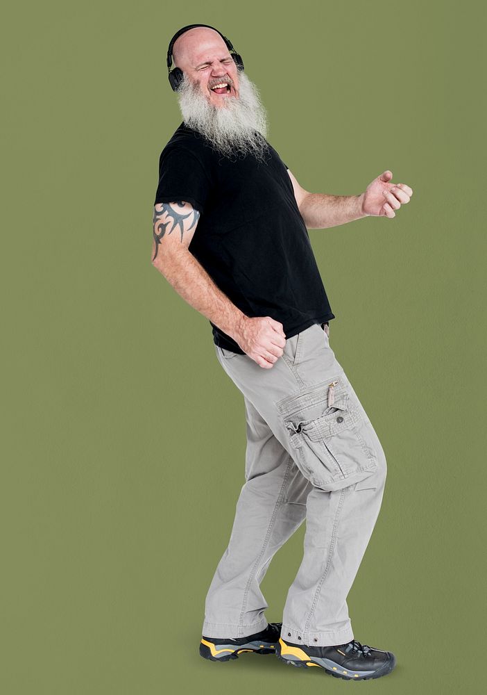 Studio portrait of a bearded man listening to music playing air guitar