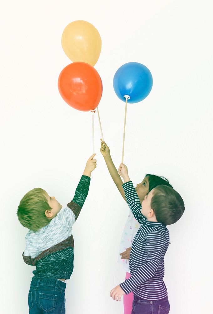 Little boys playing balloon togetherness on white background