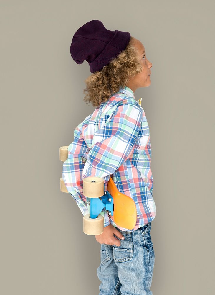 Boy holding a skateboard behind his back