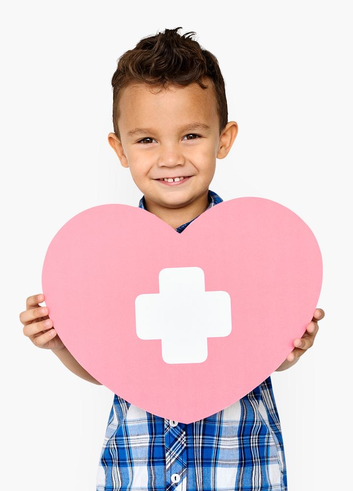 Little boy smiling and holding a medical care symbol