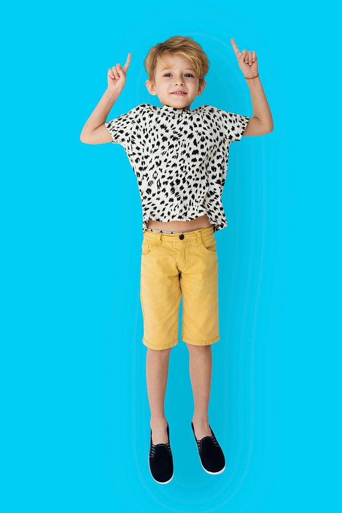 Young blonde boy jumping mid-air portrait