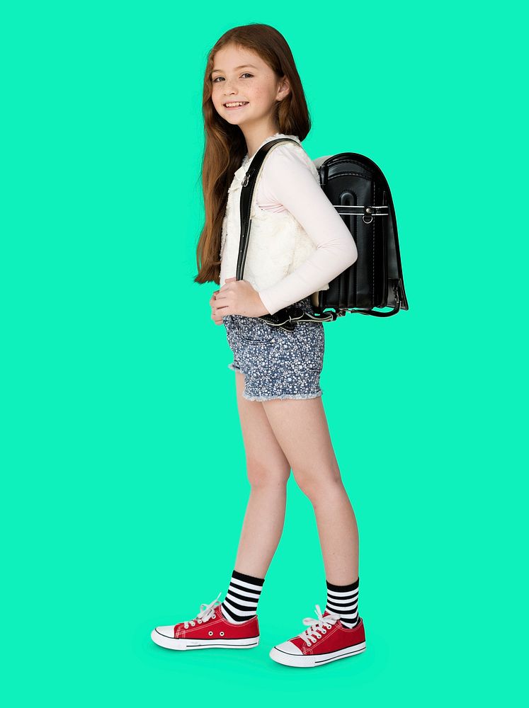 Young freckled girl carrying a backpack smiling portrait