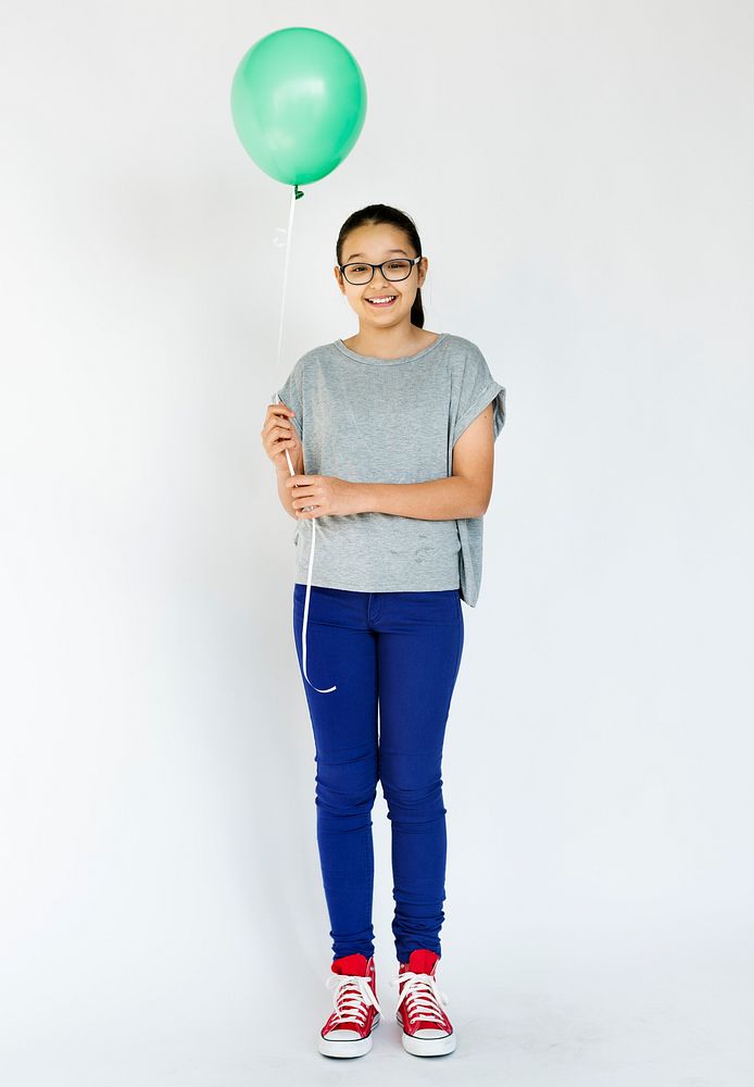 Young girl holding balloon and posing for photoshoot