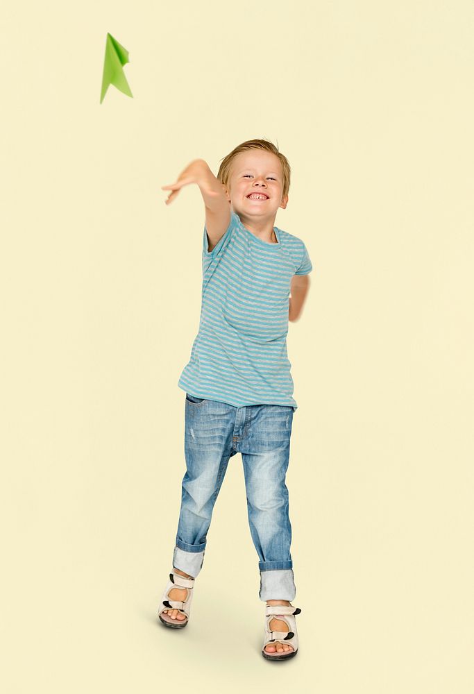 Happiness little boy smiling and flying paper airplane studio portrait