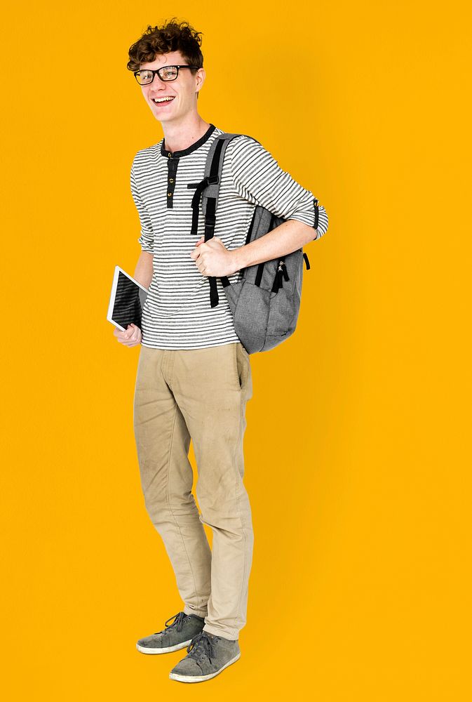 Caucasian young man standing with backpack and tablet