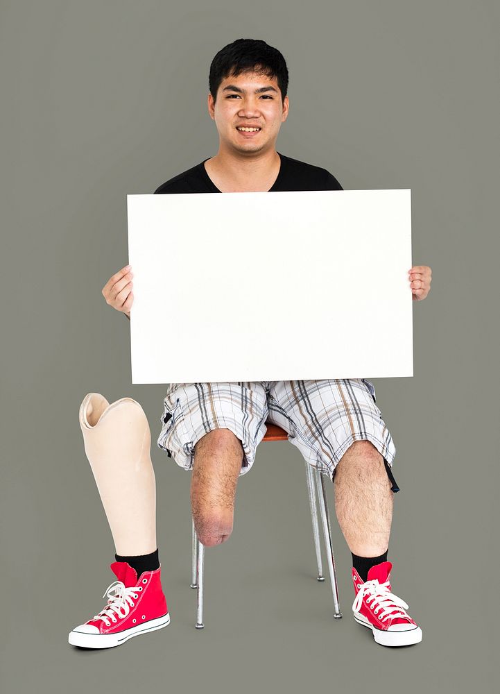 Disability Young Man with Prosthesis Leg Holding Blank Paper Board Studio Portrait