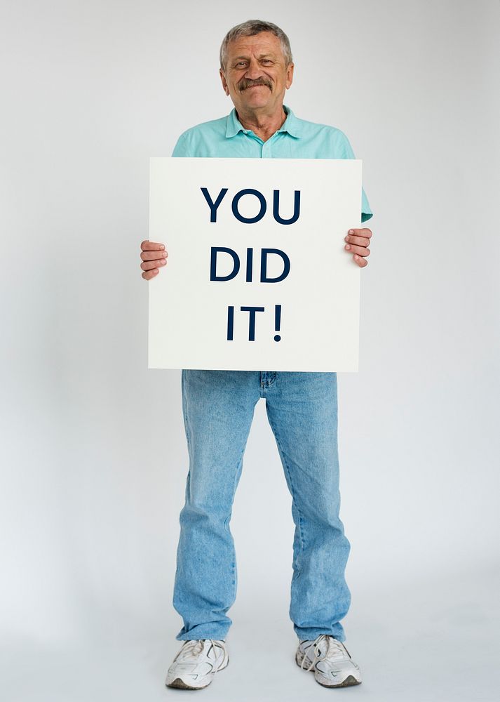 Senior adult man smiling and holding you did it banner