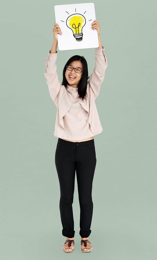 Young adult asian girl smiling and holding light bulb banner