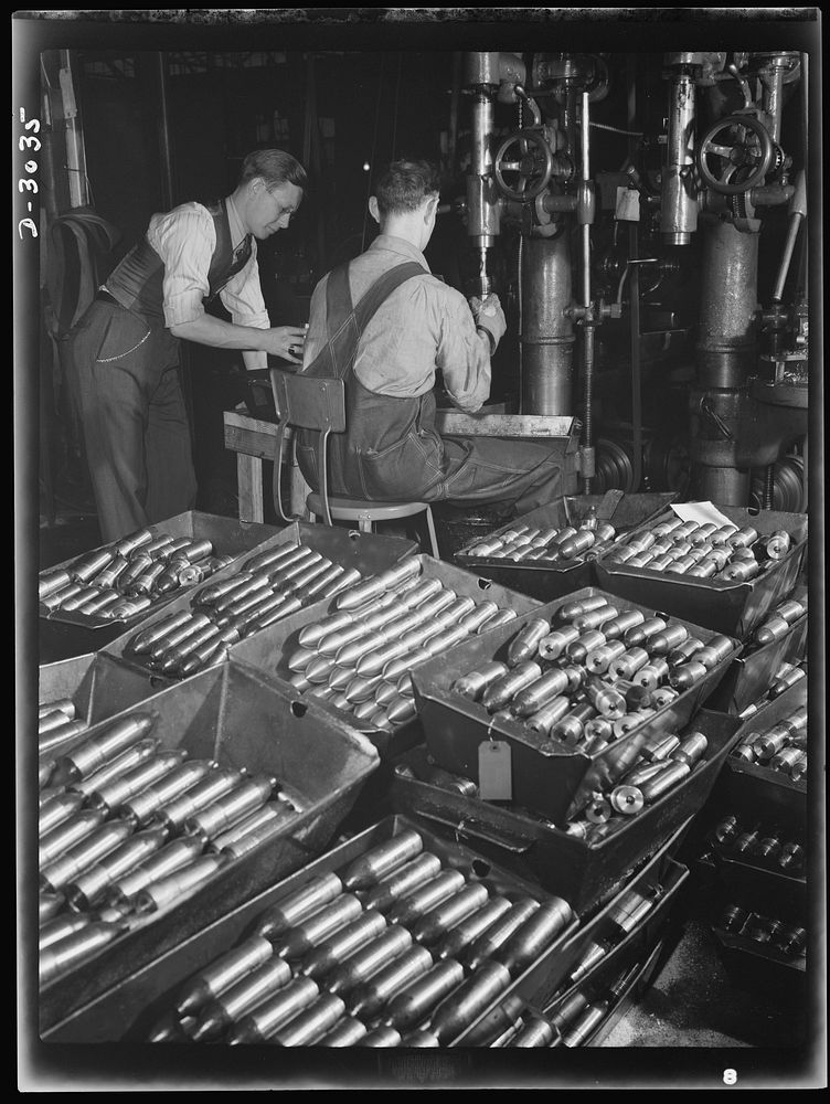 Aluminum casting. In this large Midwest factory converted to production of war essentials two workmen are pictured boring…