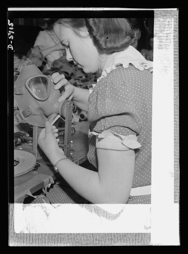 Women in industry. Gas mask production. The grim realities of war are brought home to this twenty-one-year-old worker in a…