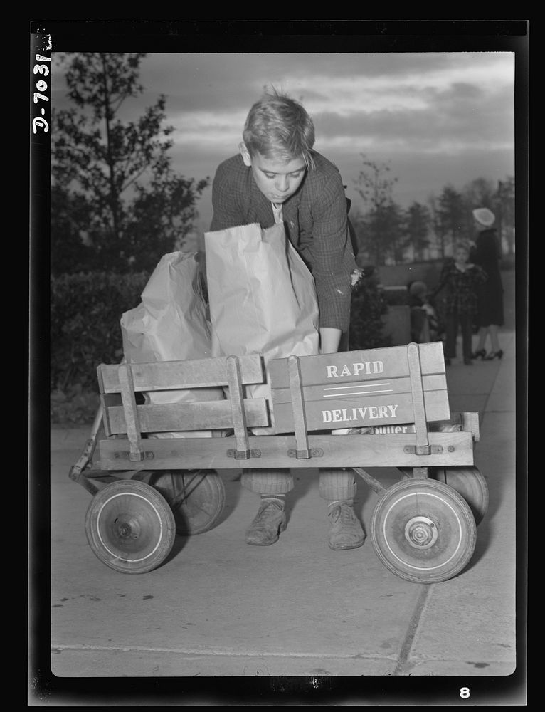 I'll carry mine. Junior's express wagon comes of age and assumes new importance in wartime America's shopping expeditions.…