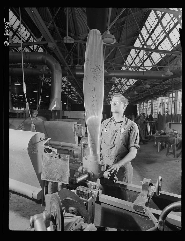 Production. Airplane propellers. John Sonesen, propeller blade grinder at a Hartford, Connecticut plant, inspects a blade…