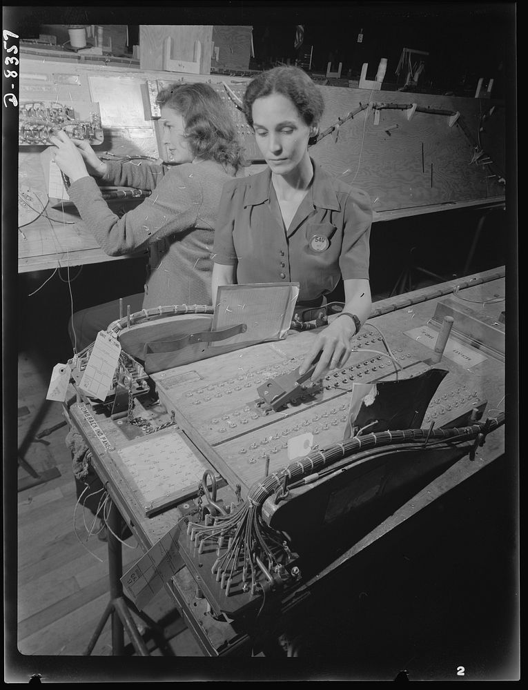 Production. B-17F heavy bomber. Checking electrical wiring assemblies for B-17F (Flying Fortress) bombers at the Boeing…