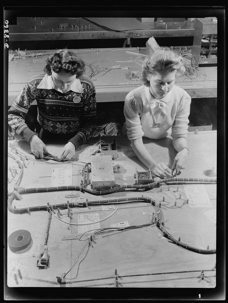 Production. B-17F heavy bomber. Electrical wiring assemblies for B-17F (Flying Fortress) bombers are made up on forming…