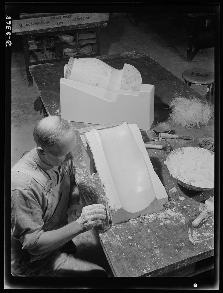 Production. B-17F heavy bomber. Bernard Garrier building up a plaster mold for a part for B-17F (Flying Fortress) bombers at…