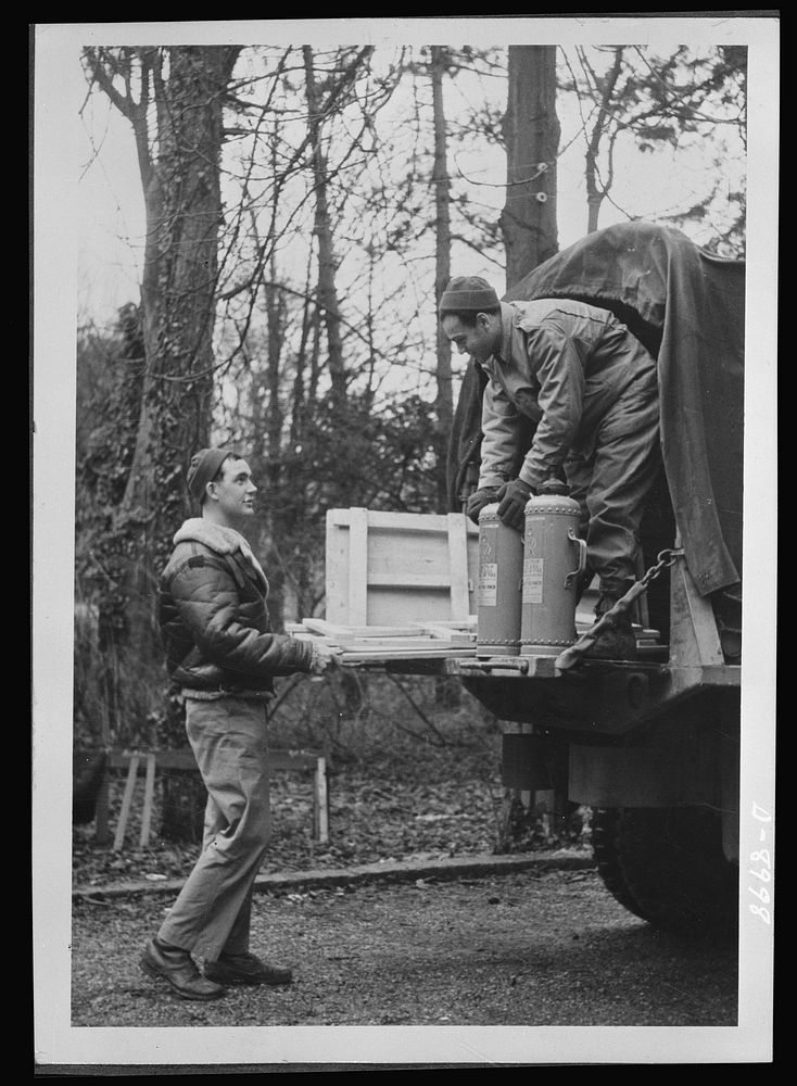 Reciprocal aid. Private Michael Fuller of New York City and Sergeant J.L. Schnider of Chicago unload British tables and fire…