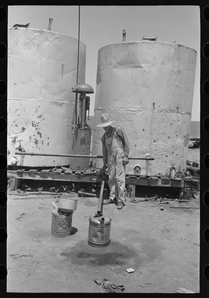 [Untitled photo, possibly related to: Pouring gasoline into tractor, large farm near Ralls, Texas. Man is day laborer] by…