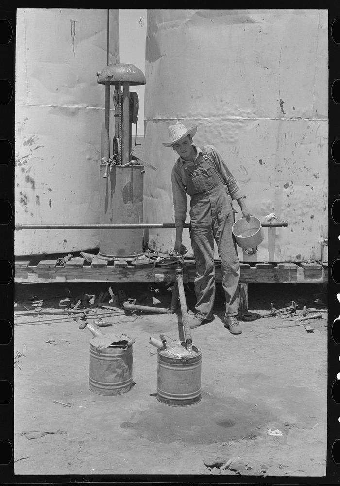 Day laborer filling five gallon cans with gasoline for use in tractors, large farm near Ralls, Texas by Russell Lee