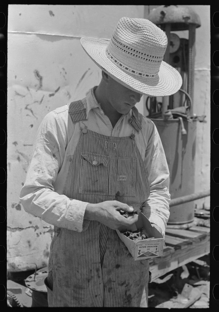 [Untitled photo, possibly related to: Day laborer looking through box of nuts and bolts, farm near Ralls, Texas] by Russell…