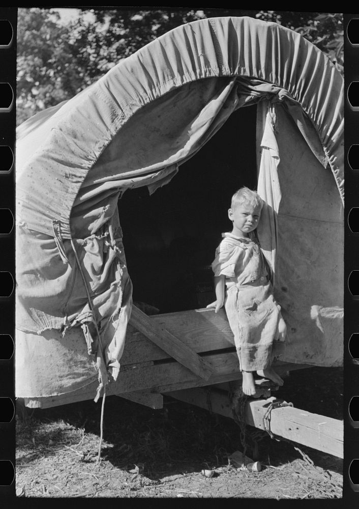 [Untitled photo, possibly related to: Son of white migrant stepping from covered wagon-type trailer, Wagoner County…