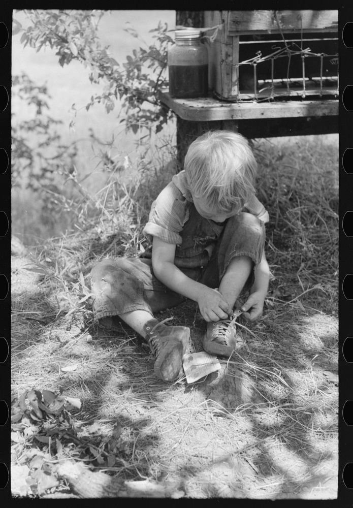 [Untitled photo, possibly related to: Child of family encamped in the open after leaving the Arkansas River bottoms because…