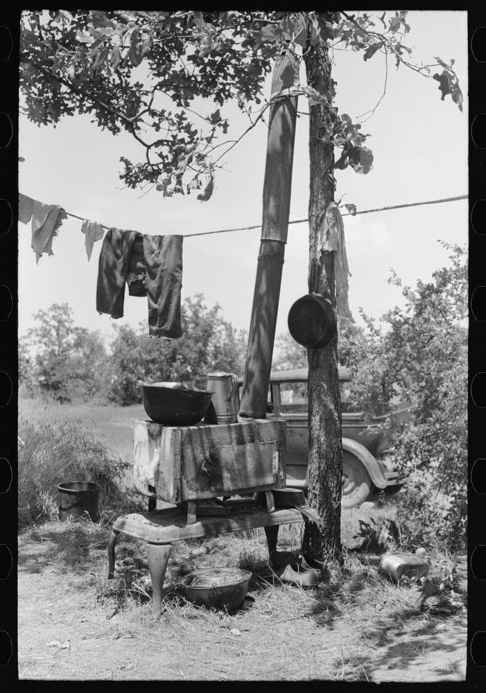 Stove and personal belongings of agricultural family camped by the roadside near Spiro. Sequoyah County, Oklahoma by Russell…