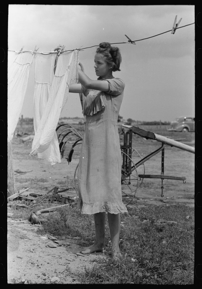 Daughter of tenant farmer hanging up clothes near Warner, Oklahoma by Russell Lee
