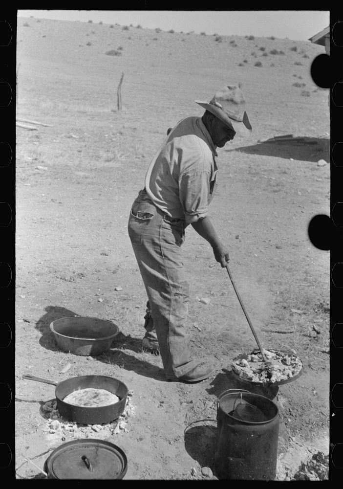 Cook lifting lid full of coals from dutch oven used for baking bread near Marfa, Texas by Russell Lee