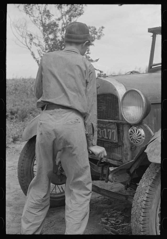 [Untitled photo, possibly related to: Migrant boy getting ready to crank his car, Muskogee, Oklahoma] by Russell Lee