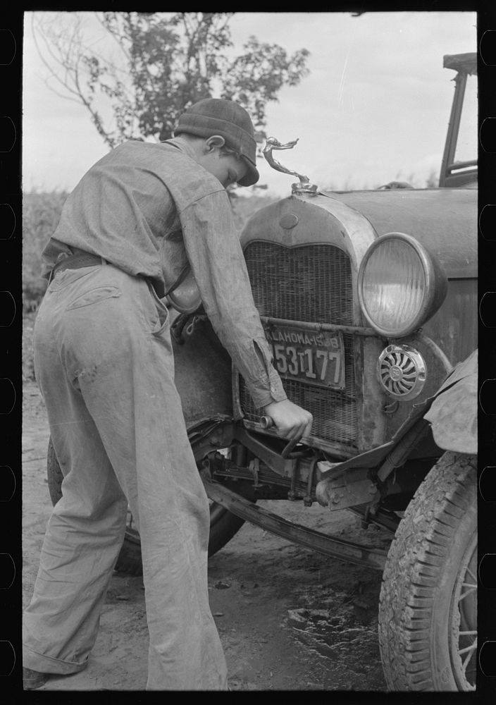 Migrant boy getting ready to crank his car, Muskogee, Oklahoma by Russell Lee