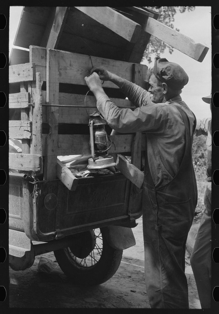 Tying lantern onto the back of improvised truck which will travel to California near Muskogee, Oklahoma by Russell Lee