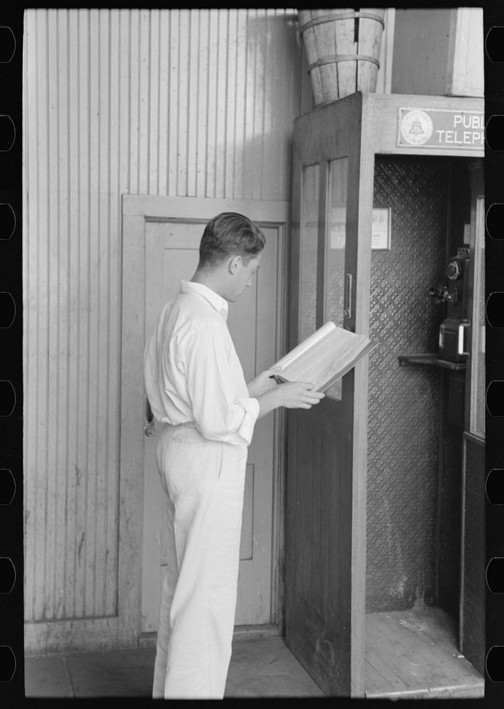 [Untitled photo, possibly related to: Man looking up telephone number. Streetcar terminal, Oklahoma City, Oklahoma] by…