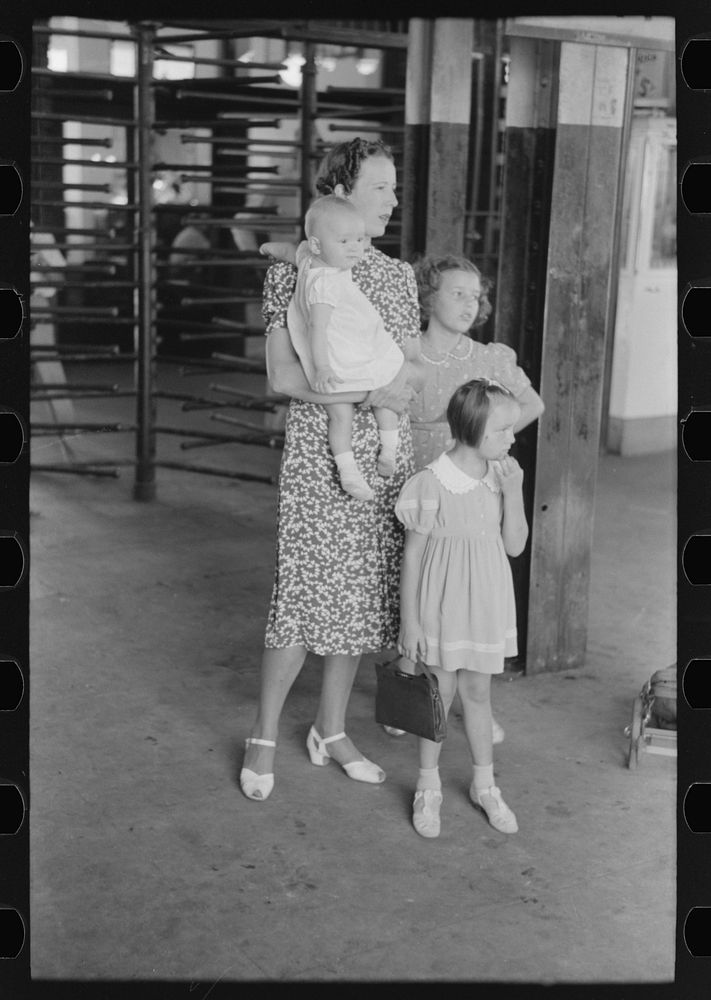 Mother with children trying to locate the streetcar they want to catch. Streetcar terminal, Oklahoma City, Oklahoma by…