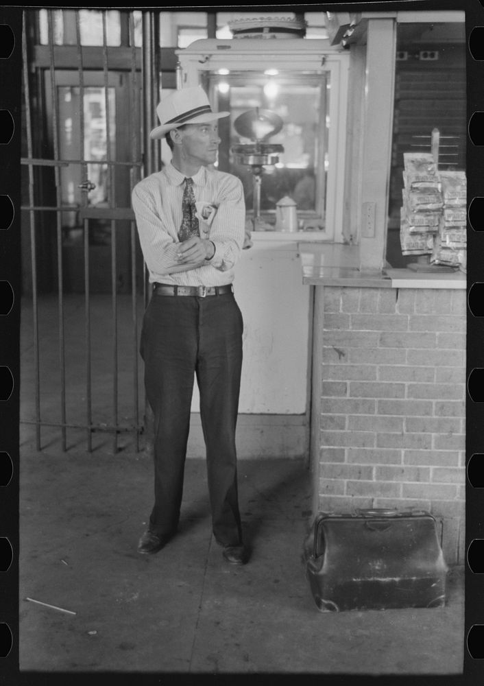 Man with luggage waiting for streetcar. Terminal, Oklahoma City, Oklahoma by Russell Lee