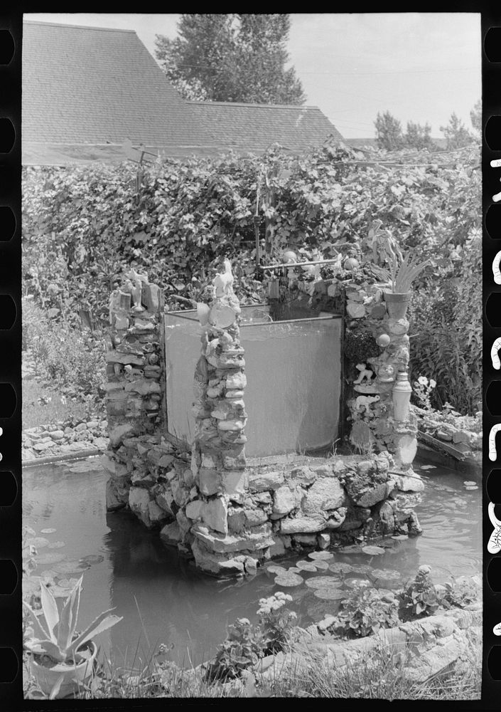 Fountain and goldfish tank in garden of Italian merchant in Cimarron, New Mexico by Russell Lee