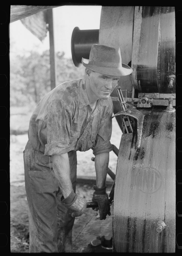 Examining mud from bottom of hole to determine characterisitcs of stratum through which they are drilling oil. Near Saint…