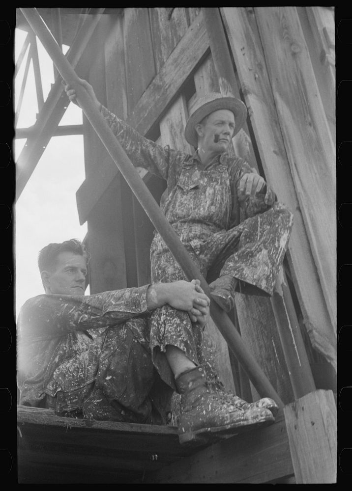 Roustabouts during a lull in painting of derrick. Seminole oil field, Oklahoma by Russell Lee