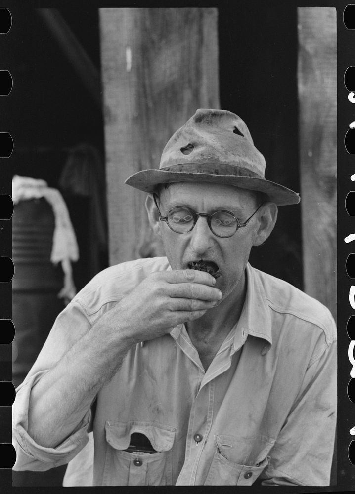 [Untitled photo, possibly related to: Roustabout taking chew of tobacco, Seminole oil field, Oklahoma] by Russell Lee