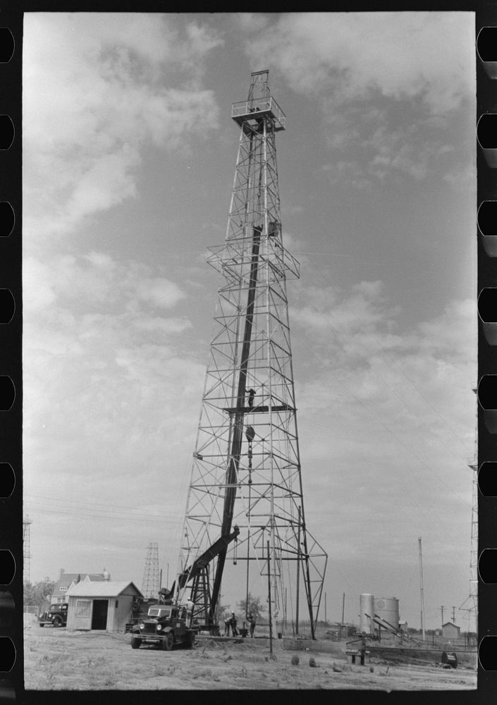 Oil derrick, Oklahoma City, Oklahoma. Workers are pulling out pipe by Russell Lee