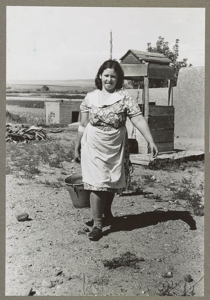 Child of Spanish-American FSA (Farm Security Administration) client bringing water from well, Taos County, New Mexico by…