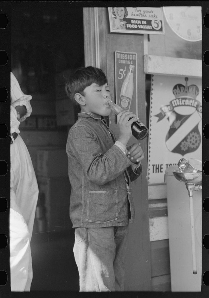 [Untitled photo, possibly related to: Mexican migrant drinking cold drink at filling station where truck has stopped en…