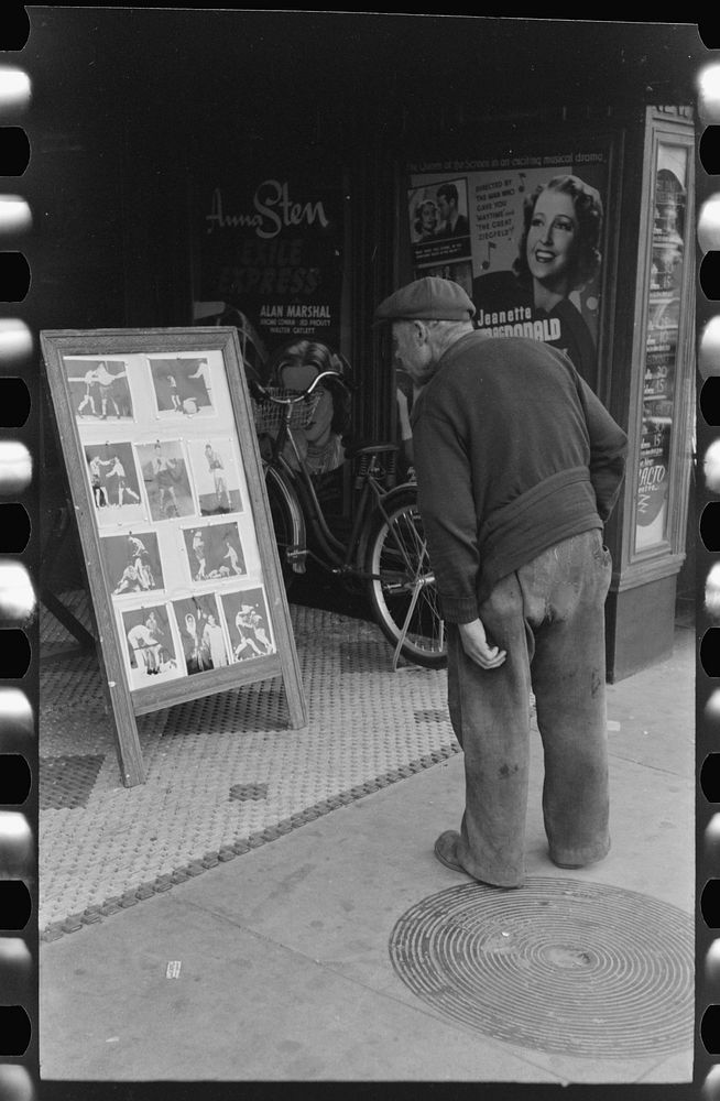 Old man looking at stills of Joe Lewis fight picture, Windsor Locks, Connecticut by Russell Lee