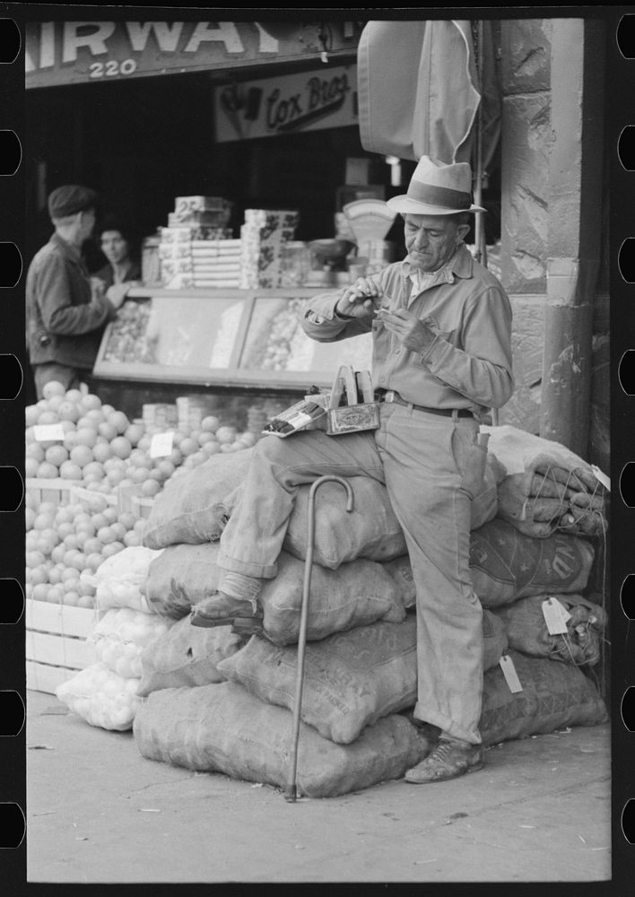 Street vendor rolling cigarette, market square, Waco, Texas by Russell Lee