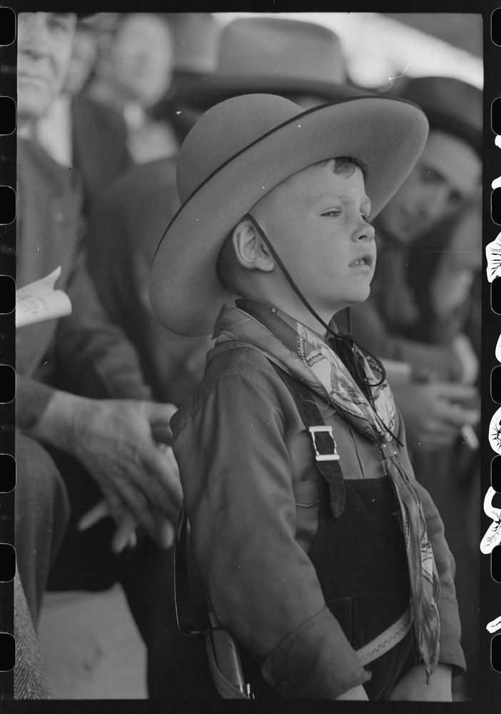 Youngster in cowboy costume watching the rodeo at the San Angelo Fat Stock Show, San Angelo, Texas by Russell Lee