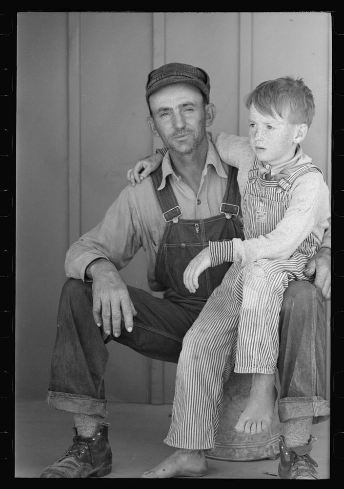 Migratory laborer and his son living at the Agua Fria Migratory Labor Camp, Arizona by Russell Lee